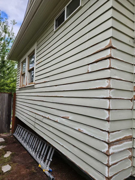 Before: corner of house with peeling paint and exposed wood damage
