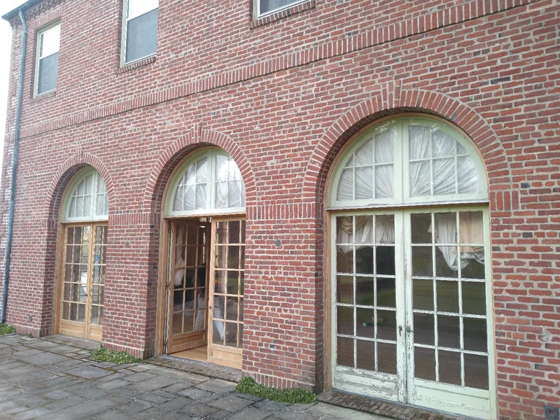 Historic brick building facade with arched windows during restoration